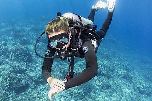 Scuba diver underwater interacting with Galileo 3 Dive Computer settings
