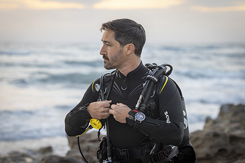 Male scuba diver looking toward water, wearing SCUBAPRO Galileo 3 Titanium